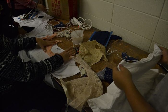 Glue gun station where students are gluing fabric to their shirts.