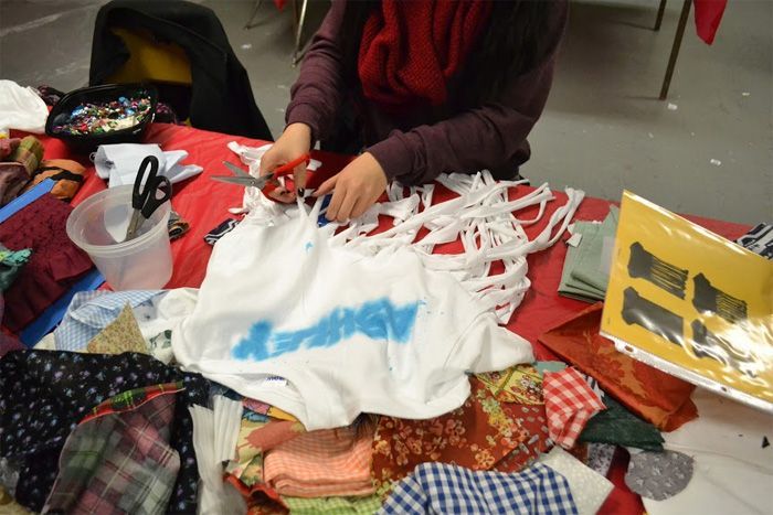 Student cutting her own t-shirt.