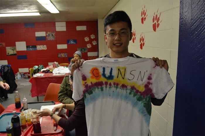 Student holds up hand made shirt representing his own creativity.