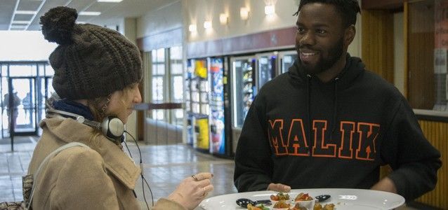 A student inspects samples of Caribbean food being offered throughout the Union. Photo by Janelle Clausen.