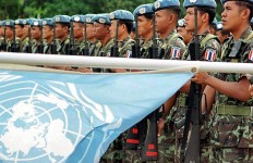 LOS PALOS, EAST TIMOR - JULY 23:  United Nations Peacekeeping Forces (UNPKF) from Thailand hold their guns up during a ceremony to mark the handover responsibility between UN peacekeeping troops and East Timor armed forces in Los Palos, East Timor, 23 July 2002. East Timor's army replaced UN peacekeepers in one district of the new nation -- the first step in a 20-month handover which will see the blue berrets bow out.   (FILM)  (Photo credit should read ANTONIO DASIPARU/AFP/Getty Images)